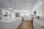 Bright kitchen with tile backsplash and quartz countertops.